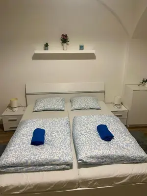two beds with blue pillows in a bedroom at Cozy Budget Studio by F&S in Prague