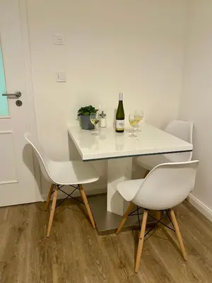 a white table with two chairs and a bottle of wine at Cozy Budget Studio by F&S in Prague