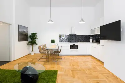 a kitchen with white cabinets and a table with chairs at Apartment Jindrisska in Prague