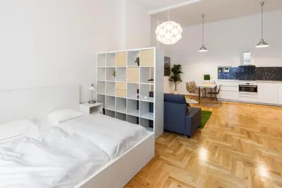 a white bedroom with a bed and a living room at Apartment Jindrisska in Prague