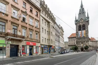 an empty city street with buildings and a clock tower at Apartment Jindrisska in Prague