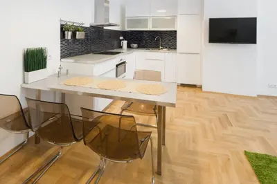a kitchen with white cabinets and a table and chairs at Apartment Jindrisska in Prague