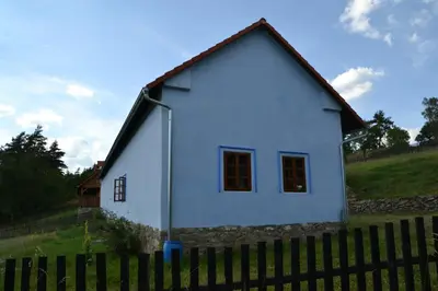 a small white house behind a fence at Country house - Slapy/Pazderny in Žďár