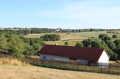 a white barn with a red roof in a field at Country house - Slapy/Pazderny in Žďár