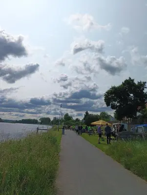 people walking along a path next to a body of water at Camp in Horní Počaply