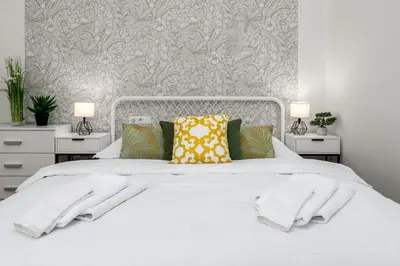a bedroom with a white bed with two night stands at Botanica Suite Prague in Prague