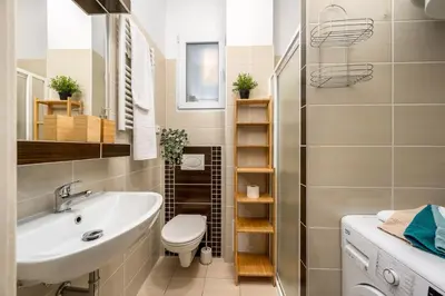 a bathroom with a white sink and a toilet at Botanica Suite Prague in Prague