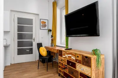 a living room with a television on a wall at Botanica Suite Prague in Prague
