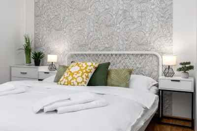 a bedroom with a white bed with two night stands at Botanica Suite Prague in Prague