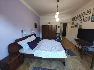 a bedroom with a bed and a desk and a television at Prague-2 Vinohrady Apartment in Prague