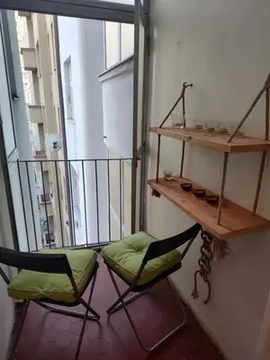 a room with two chairs and a shelf on a balcony at Prague-2 Vinohrady Apartment in Prague