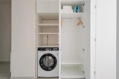a white closet with a washing machine in it at Blueground Holešovice city view nr Vltava PRG-51 in Prague
