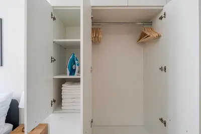 a kitchen with a stainless steel sink and wooden cabinets at Blueground Holešovice balcony nr Vltava PRG-55 in Prague