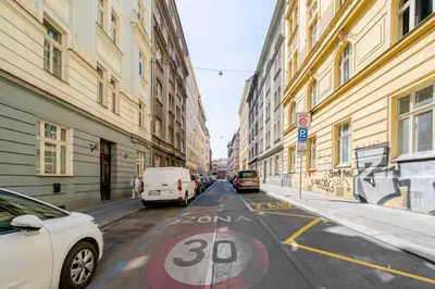 a cobblestone street in a city with buildings and cars at Blueground Holešovice balcony nr Vltava PRG-55 in Prague