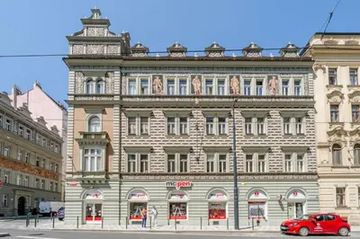 a large building with a red car parked in front of it at Blueground Holešovice balcony nr Vltava PRG-55 in Prague
