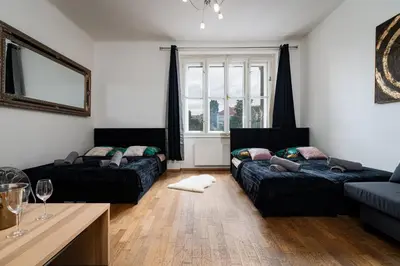 a living room with two beds and a table at Aurora Estate Elegance in Prague