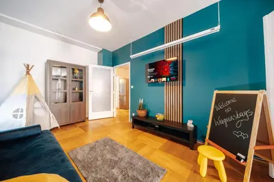 a living room with a blue wall and a chalkboard at Central Riverside 2BD Apt by Vltava & Theater in Prague