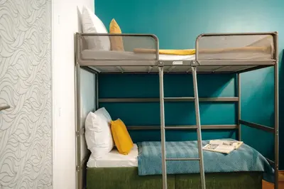 a bunk bed with a chair in a room at Central Riverside 2BD Apt by Vltava & Theater in Prague