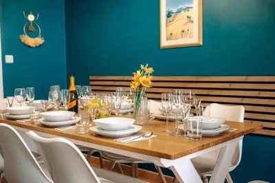 a wooden table with white plates and glasses on it at Central Riverside 2BD Apt by Vltava & Theater in Prague