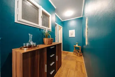 a room with blue walls and a wooden cabinet at Central Riverside 2BD Apt by Vltava & Theater in Prague