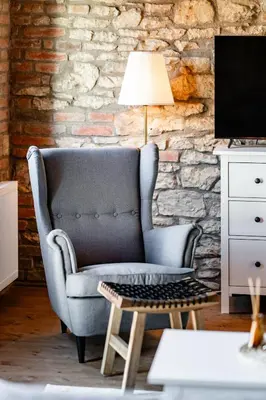 a living room with a blue chair and a lamp at Statek Pazderna