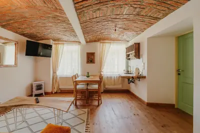 a living room with a wooden ceiling and a table at Statek Pazderna