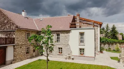 a large stone house with a red roof at Statek Pazderna