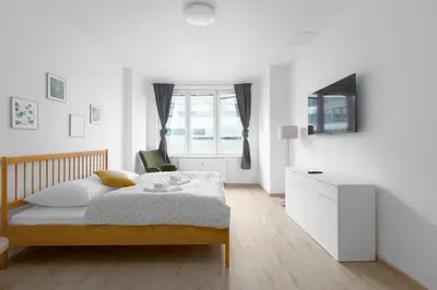 a white bedroom with a bed and a desk at Apartment - 2 bedrooms, kitchen, close to metro in Prague