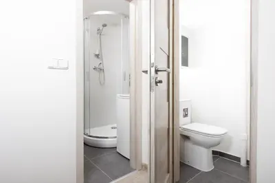 a white bathroom with a toilet and a shower at Apartment - 2 bedrooms, kitchen, close to metro in Prague