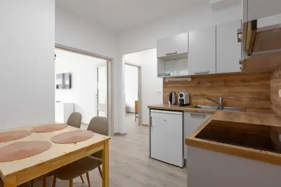 a kitchen with a wooden table and a counter top at Apartment - 2 bedrooms, kitchen, close to metro in Prague