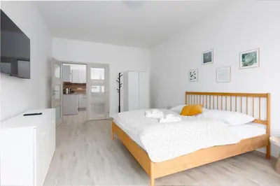 a bedroom with a large bed with white sheets at Apartment - 2 bedrooms, kitchen, close to metro in Prague