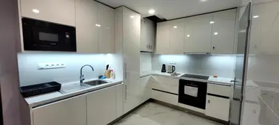 a white kitchen with a sink and a microwave at Relax Apartment in Prague