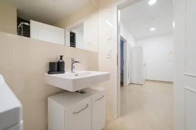 a white bathroom with a sink and a mirror at Historic Cozy Apartment with National Museum View in Prague