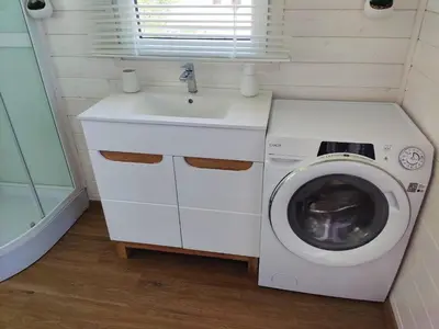 a small bathroom with a washing machine and a sink at Houseboat Daisy in Prague