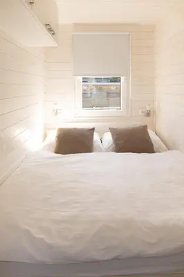 a large white bed in a room with a window at Houseboat Daisy in Prague