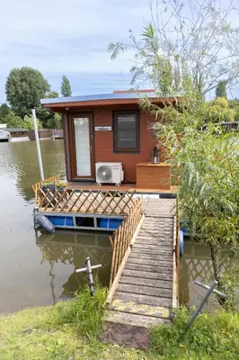a tiny house on a dock on a body of water at Houseboat Daisy in Prague