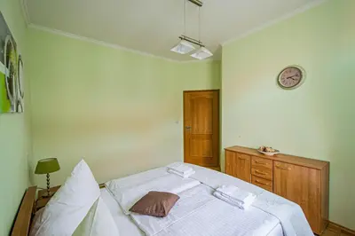 a bedroom with a bed and a clock on the wall at Riverside Ruterra Apartment in Prague