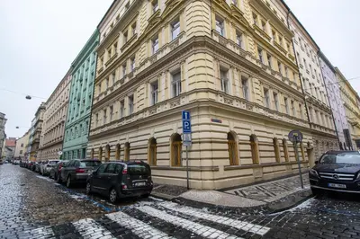 a large building with cars parked in front of it at Riverside Ruterra Apartment in Prague
