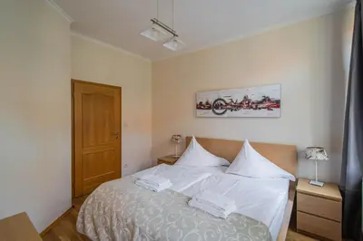 a bedroom with a large bed with white sheets at Riverside Ruterra Apartment in Prague