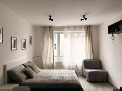 a bedroom with a bed and a chair and a window at UrbanFlat1615 with Parking in Prague