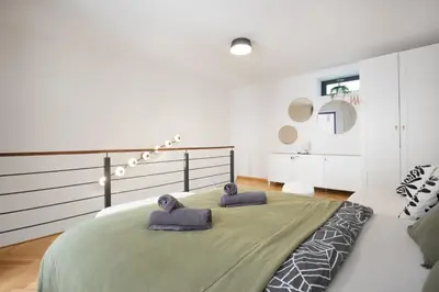 a bedroom with a large bed with two towels at Atelier in the Heart of Karlín in Prague