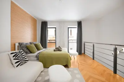 a bedroom with a bed and a white couch at Atelier in the Heart of Karlín in Prague