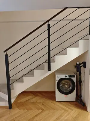 a washing machine under a staircase with a washing machine under it at Atelier in the Heart of Karlín in Prague