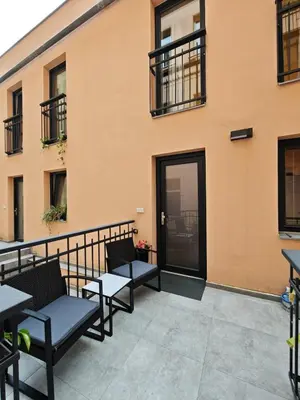 a patio with tables and chairs in front of a building at Atelier in the Heart of Karlín in Prague