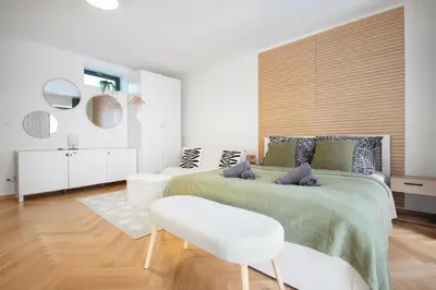 a bedroom with a large bed and a chair at Atelier in the Heart of Karlín in Prague