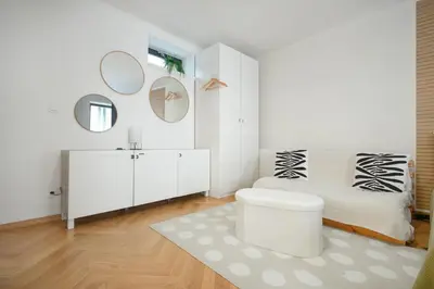 a white bathroom with mirrors and a stool in it at Atelier in the Heart of Karlín in Prague