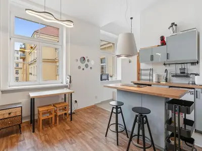 a kitchen with a counter and some chairs and a window at Studio Art District Nook by Interhome in Prague