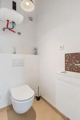 a white bathroom with a toilet and a light at Studio Art District Nook by Interhome in Prague