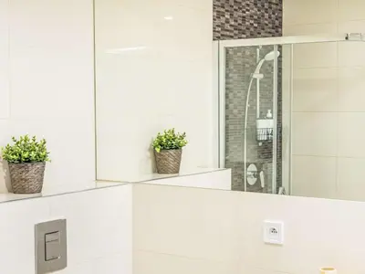 a white bathroom with two potted plants on the wall at Apartment Washington-2 by Interhome in Prague