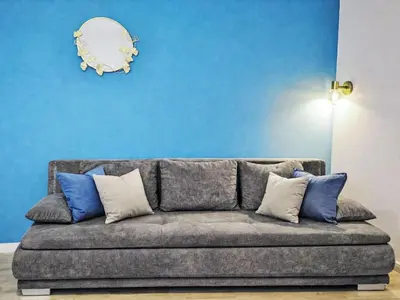 a couch in a living room with a blue wall at Apartment Washington-2 by Interhome in Prague